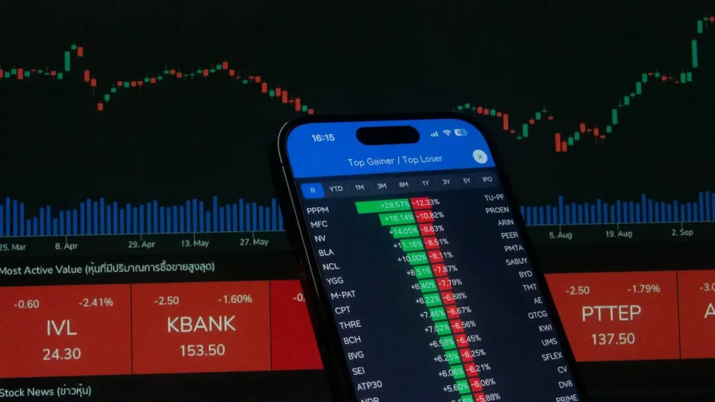Teléfono celular mostrando una aplicación financiera con variaciones de precios para invertir en acciones tecnológicas de forma estratégica